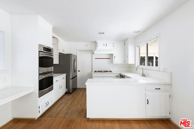 kitchen with white cabinets, appliances with stainless steel finishes, sink, and dark hardwood / wood-style floors