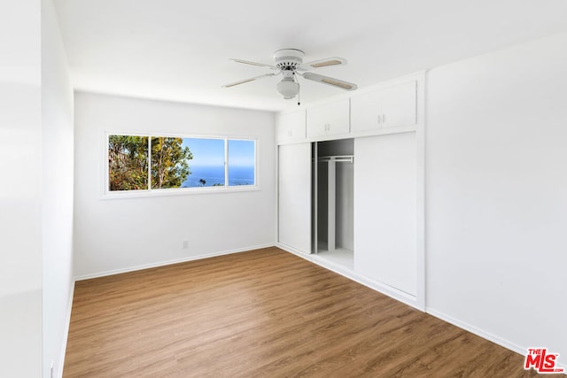 unfurnished bedroom featuring ceiling fan, a closet, and light hardwood / wood-style floors