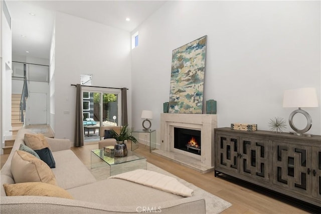 living room with light hardwood / wood-style flooring and a towering ceiling