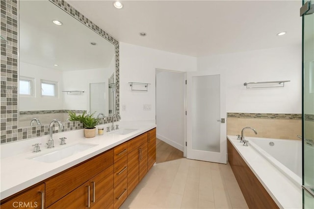 bathroom featuring tile patterned flooring, a washtub, and vanity