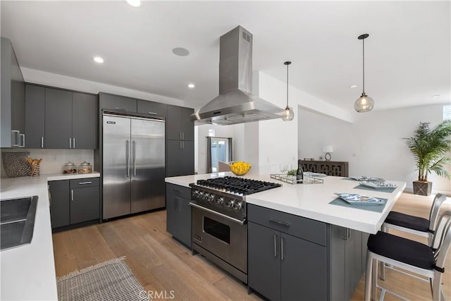 3308 Pacific Ave, Manhattan Beach, CA 90266 - kitchen with premium appliances, island exhaust hood, decorative light fixtures, light wood-style floors, and light countertops