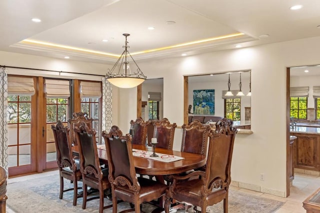 dining area with a tray ceiling and plenty of natural light