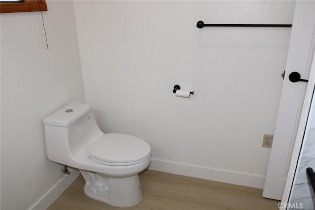 bathroom with toilet and hardwood / wood-style floors