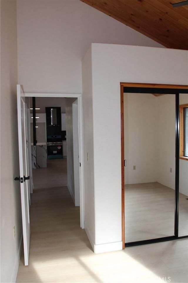 hallway with vaulted ceiling and wooden ceiling