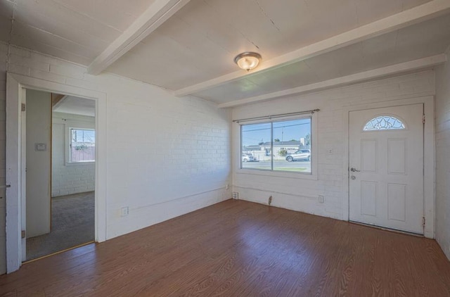 entryway with a wealth of natural light, brick wall, and beam ceiling