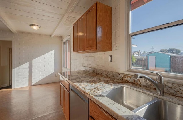 kitchen with wooden ceiling, beam ceiling, brick wall, stainless steel dishwasher, and sink