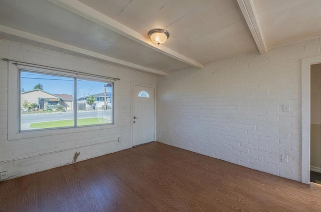 entrance foyer with brick wall, dark hardwood / wood-style floors, and beam ceiling