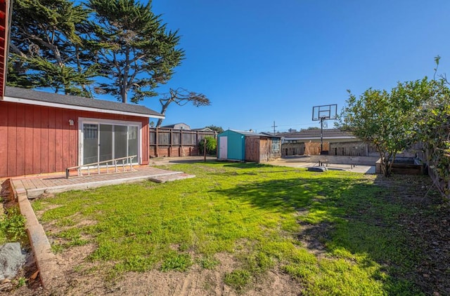 view of yard featuring a storage unit and a patio area