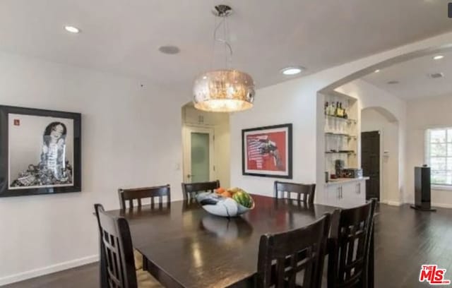 dining room featuring built in shelves and dark hardwood / wood-style flooring