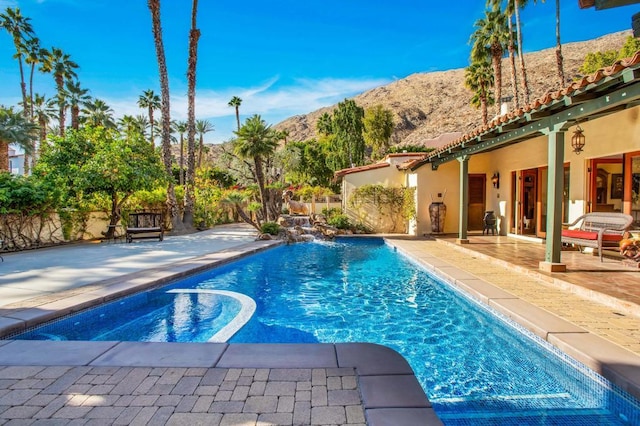 view of swimming pool featuring a mountain view and a patio