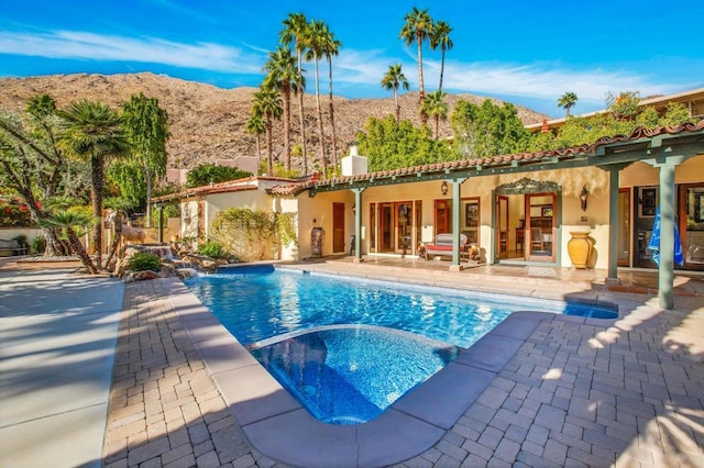 view of pool with a mountain view, an in ground hot tub, and a patio area