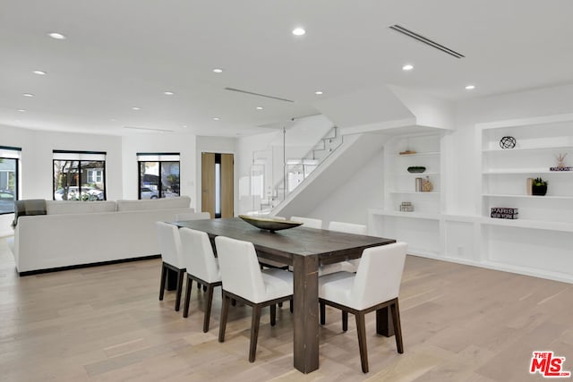 dining room with light hardwood / wood-style floors and built in features