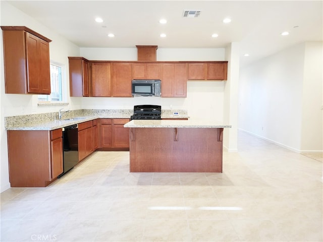 kitchen featuring light tile patterned floors, a kitchen island, black appliances, light stone counters, and sink