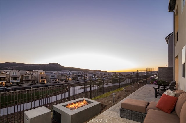 patio terrace at dusk featuring a mountain view and a fire pit