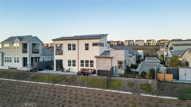 back of property with a patio and solar panels