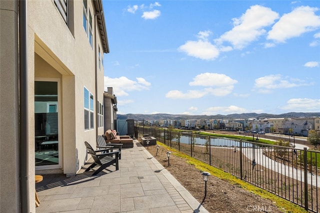 view of patio / terrace featuring a water and mountain view