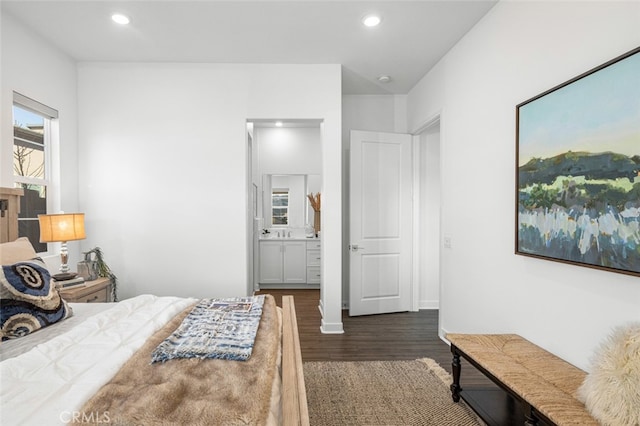 bedroom with ensuite bathroom and dark hardwood / wood-style flooring