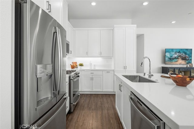 kitchen featuring appliances with stainless steel finishes, sink, white cabinets, and dark hardwood / wood-style flooring