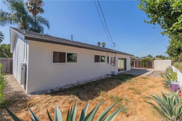 rear view of house featuring a lawn and a patio