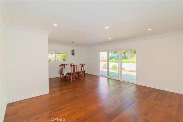 empty room featuring dark hardwood / wood-style flooring, a wealth of natural light, and ornamental molding