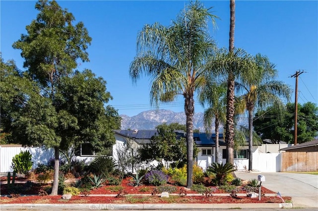 view of front of property with a mountain view and solar panels