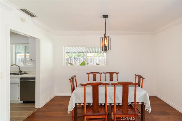 dining area featuring dark wood-type flooring, sink, and crown molding