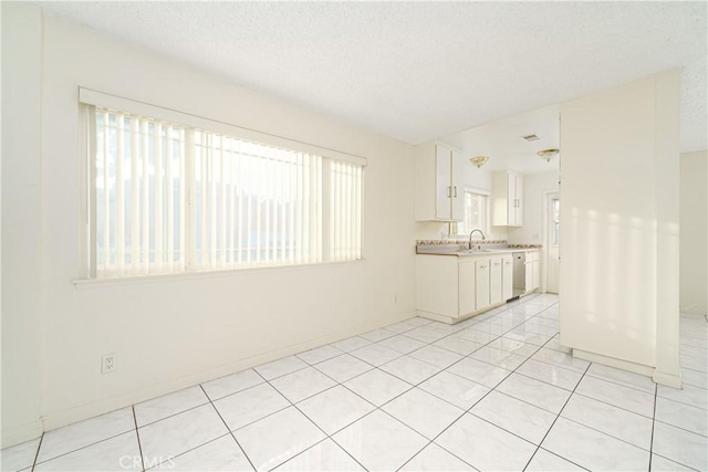 tiled empty room with sink and a textured ceiling