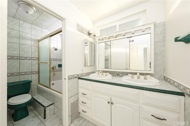 full bathroom with vanity, tile walls, enclosed tub / shower combo, and toilet