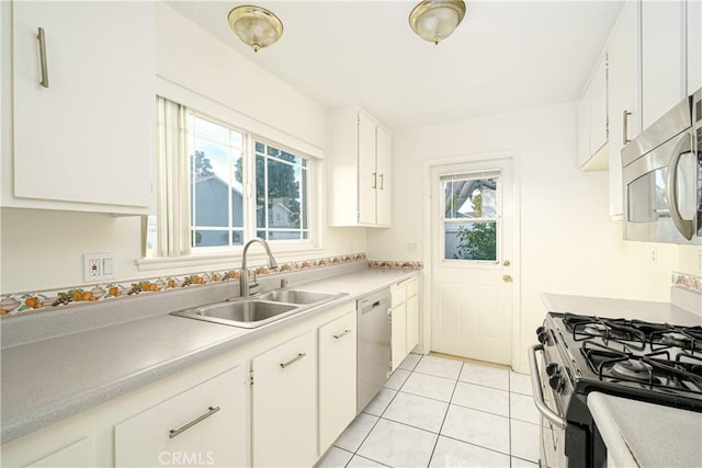 kitchen with stainless steel appliances, white cabinetry, sink, and light tile patterned floors