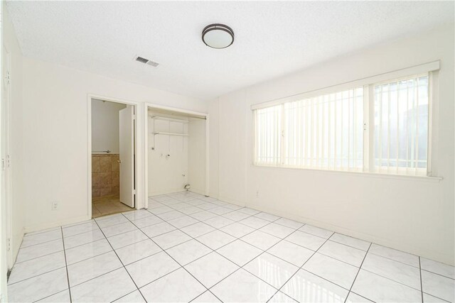 unfurnished bedroom featuring light tile patterned flooring and a closet