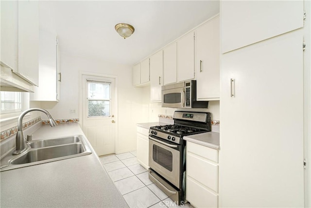 kitchen featuring light tile patterned flooring, appliances with stainless steel finishes, sink, and white cabinets