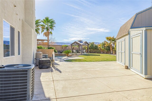 view of patio / terrace with central AC unit, a gazebo, a mountain view, and a storage unit