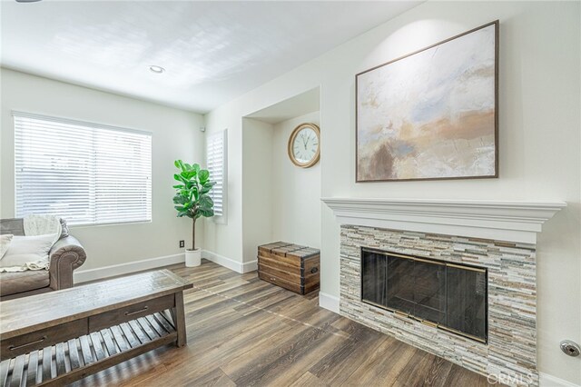 living room with dark wood-type flooring and a fireplace