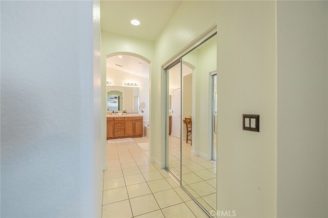 hallway with light tile patterned floors and vaulted ceiling