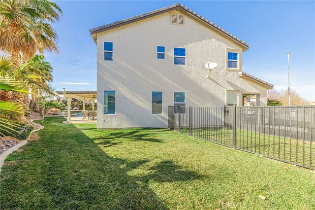 back of property featuring a patio area and a yard