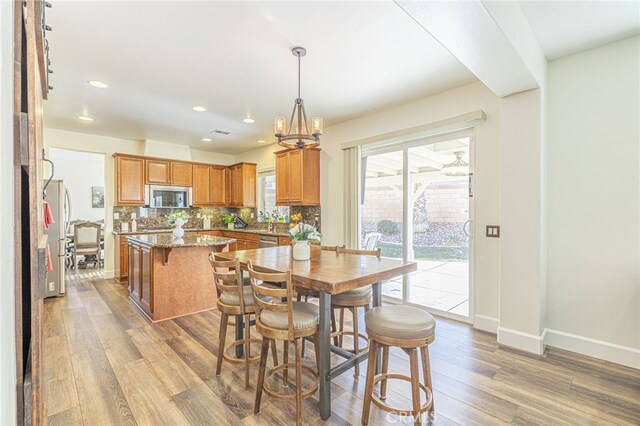 dining room featuring light wood-type flooring and an inviting chandelier