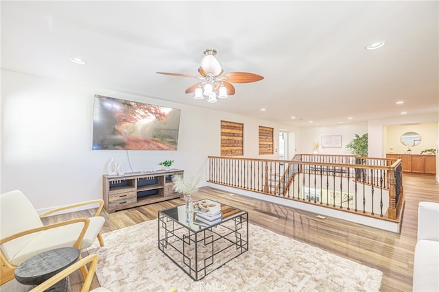 living room featuring ceiling fan and light hardwood / wood-style flooring