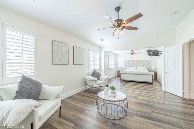 bedroom featuring ceiling fan, dark hardwood / wood-style flooring, and multiple windows