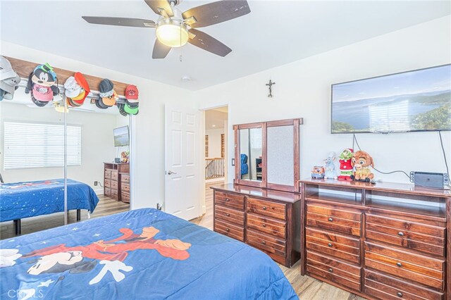 bedroom featuring light wood-type flooring, ceiling fan, a closet, and connected bathroom