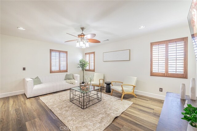 living room featuring ceiling fan and hardwood / wood-style floors