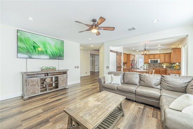 living room featuring ceiling fan and hardwood / wood-style flooring