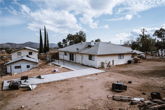 back of property with cooling unit, a mountain view, and a patio