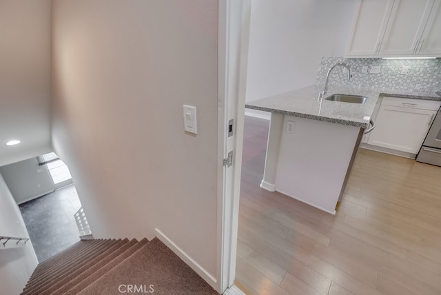 stairs with sink and hardwood / wood-style floors