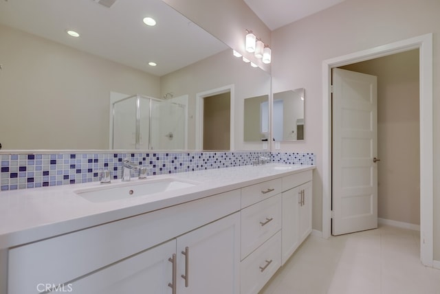 bathroom featuring a shower with door, vanity, decorative backsplash, and tile patterned floors