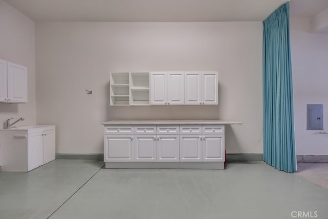 laundry room featuring electric panel and sink