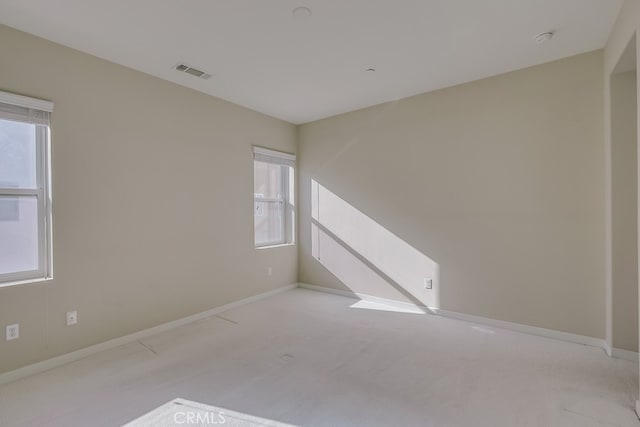 empty room with light colored carpet and a wealth of natural light