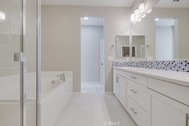 bathroom featuring plus walk in shower, tile patterned floors, backsplash, and vanity