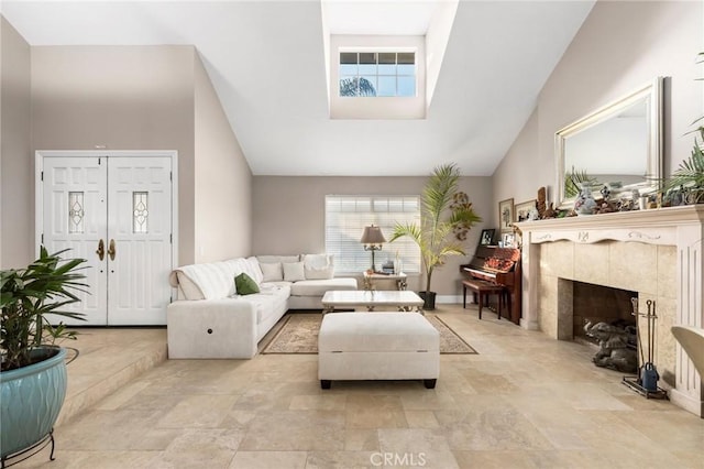 living room with a tiled fireplace and high vaulted ceiling