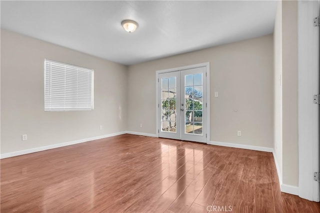 empty room featuring hardwood / wood-style flooring and french doors