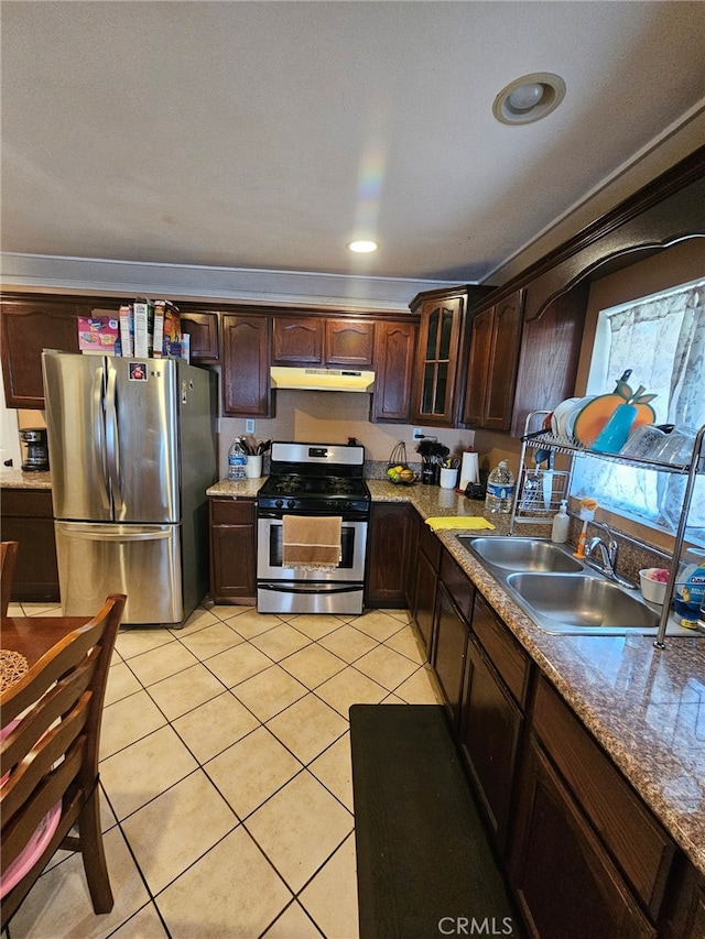 kitchen with sink, light tile patterned flooring, dark brown cabinetry, and stainless steel appliances